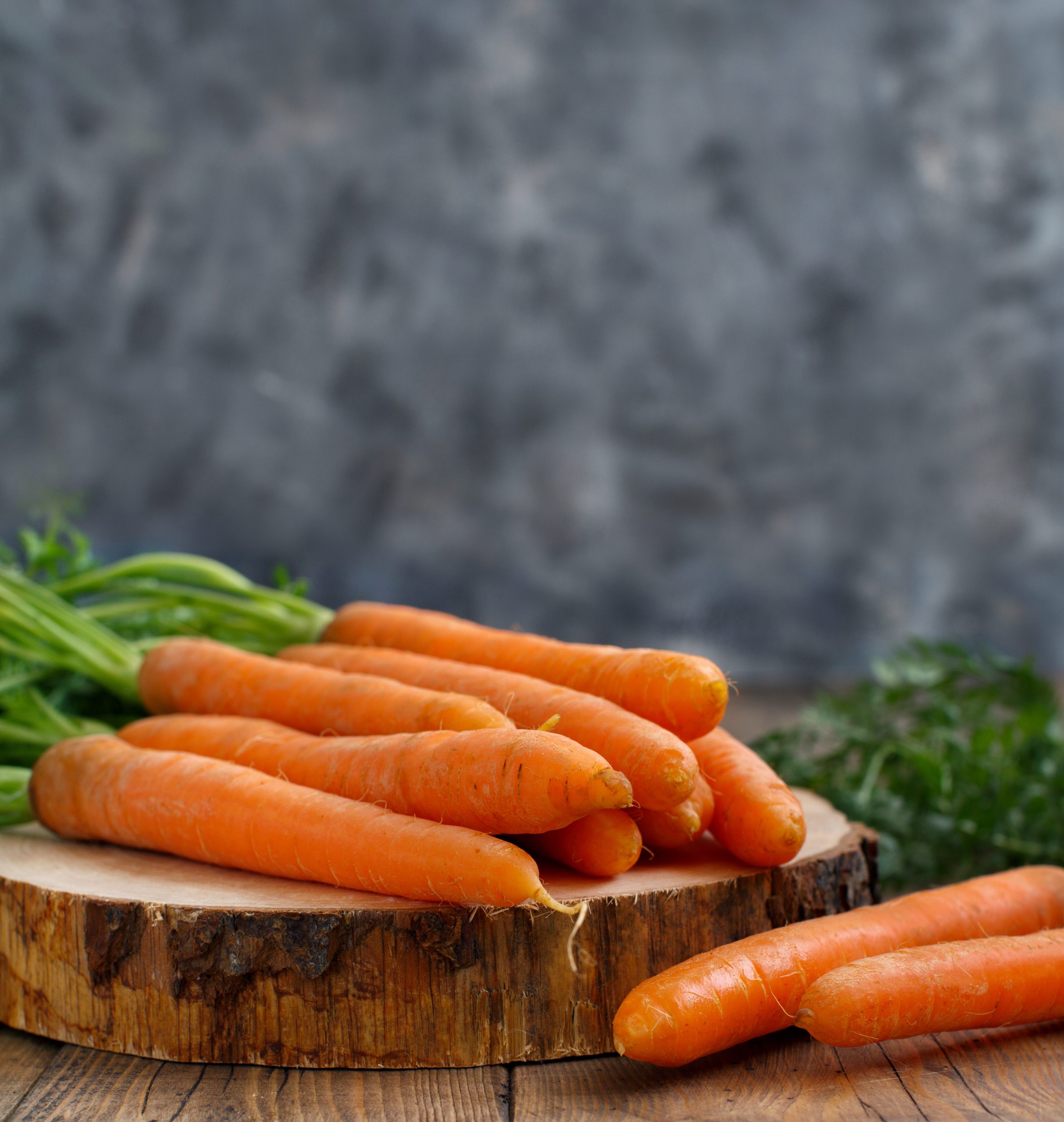 Fresh raw carrots with leaves on a wooden table